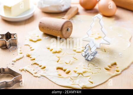 Cottura di Natale - impasto con taglierina per biscotti e ingredienti da forno Foto Stock