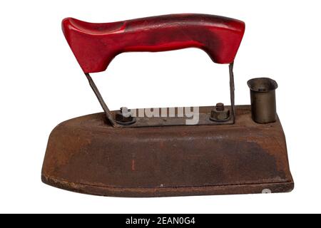 Ferro vecchio isolato. Primo piano di un vecchio ferro da stiro elettrico da sarto arrugginito professionale con manico rosso isolato su sfondo bianco. Accessori per la sartoria. Foto Stock