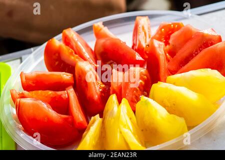 Pomodori in piatto tagliati a fette. Pomodori rossi e gialli. Foto Stock