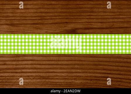 Striscia di tovaglie a scacchi verde e bianco su tavolo di legno Foto Stock