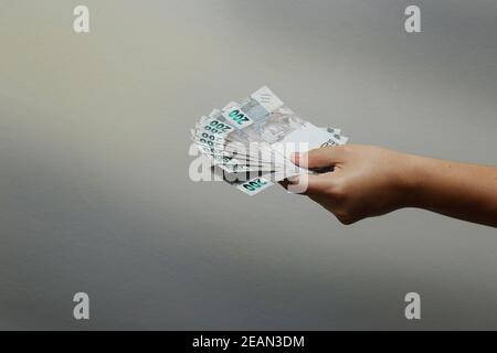 Mani in possesso di banconote reali brasiliane, banconote BRL Brasile, valuta brasiliana, economia e business. Foto Stock