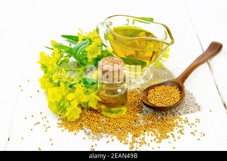 Mostarda di olio in vasi e salsa barca su tavola bianca Foto Stock
