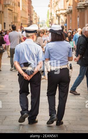 Due poliziotti in pattuglia in una strada a Bologna Italia Foto Stock