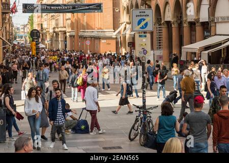 Folle di persone in una zona pedonale in una strada Nel centro di Bologna di giorno Foto Stock