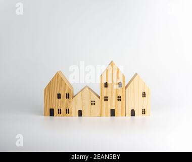 Simulato casa di legno su sfondo bianco che ospita idee di affari Foto Stock