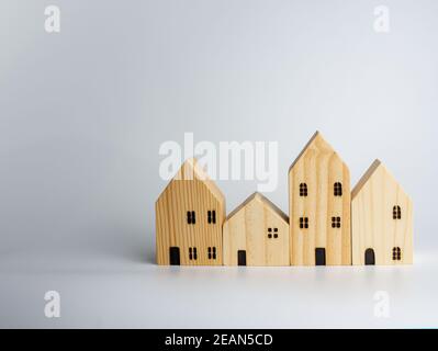 Simulato casa di legno su sfondo bianco che ospita idee di affari Foto Stock