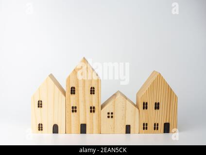 Simulato casa di legno su sfondo bianco che ospita idee di affari Foto Stock