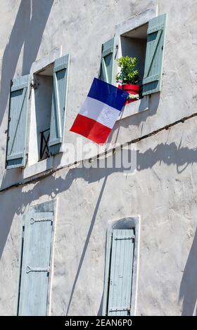 Facciata dell'edificio con le bandiere della Francia nella finestra. Foto Stock