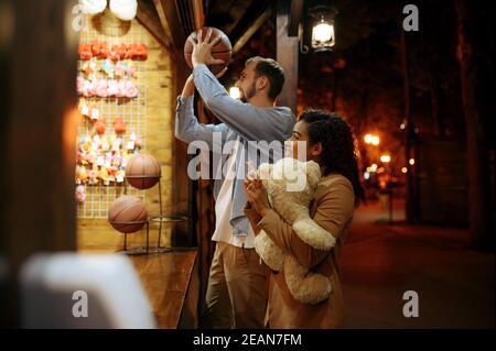 Gioco di coppia nella galleria di tiro, parco divertimenti Foto Stock