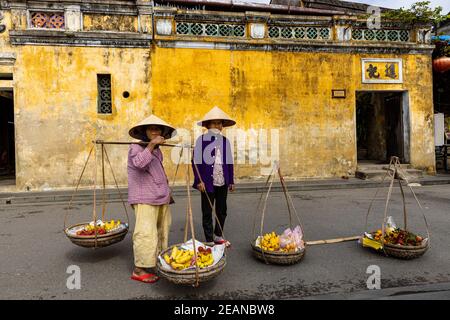 Old Woman dal Vietnam sta vendendo frutta per le strade Di Hoi An Foto Stock