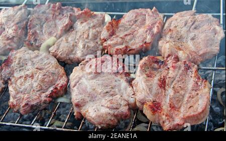 Bistecca sul barbecue. Preparazione appetitosa di maiale all'esterno Foto Stock