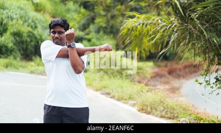 sport runner uomo nero indossare orologio lui corpo riscaldamento braccia muscoli prima di correre Foto Stock