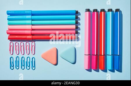 Marcatori luminosi e cancellatore su sfondo blu Foto Stock