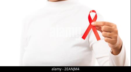 Donna che tiene il nastro rosso di consapevolezza di HIV AIDS Foto Stock