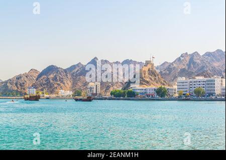 Vista della costa di Muttrah dominata da un forte su una collina, Mascate, Oman. Foto Stock