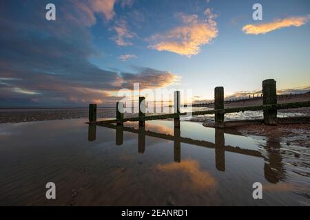 Rotting pali di legno eretti di vecchie difese marine sulla spiaggia di Winchelsea, Winchelsea, Sussex orientale, Inghilterra, Regno Unito, Europa Foto Stock