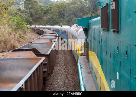 Vista del minerale di ferro vecchio treno da Companhia vale do Rio Doce che corre su binari ferroviari visti dalla finestra della locomotiva. Concetto di industria, trasporti. Foto Stock