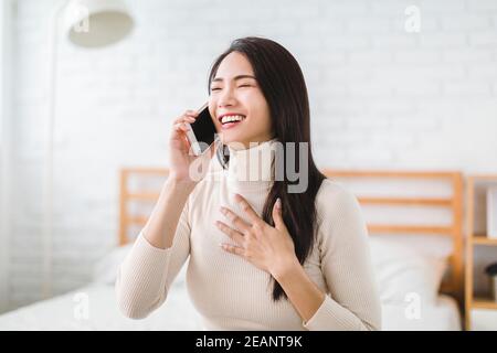 giovane donna che parla con un amico sul telefono cellulare e ride Foto Stock