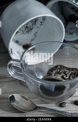 Una sporca Tazza da caffè con piattino e una tazza di caffè. Foto Stock