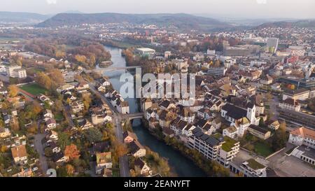 Vista sul drone della città di Brugg nord-est con il fiume Aare, quartieri residenziali e commerciali, centro storico e il ponte del casinò nel cantone Aargau i. Foto Stock