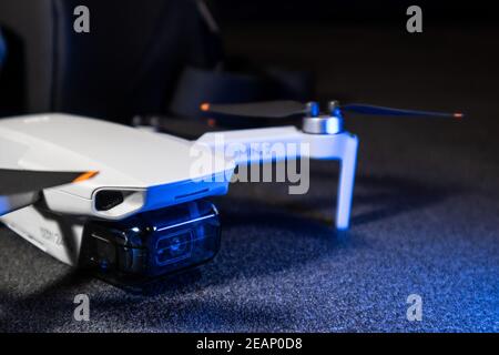 Kiev, Ucraina - 02 febbraio 2021: DJI Mavic Mini 2 drone primo piano. Nuovo quadricottero dispiegato su sfondo nero in luce blu Foto Stock
