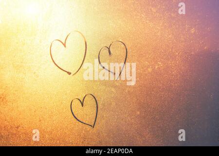 Tre cuori disegnati a mano su vetro congelato. Concetto di amore, San Valentino Foto Stock