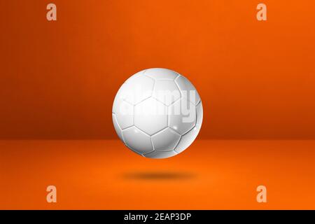 Pallone da calcio bianco su sfondo arancione dello studio Foto Stock