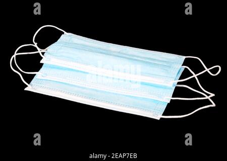 Maschera medica protettiva per il viso utilizzata durante la pandemia di covid 19 per proteggere contro il coronavirus. Diverse maschere isolate su sfondo nero Foto Stock