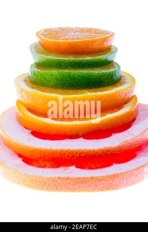 Colorato stack di agrumi fette di mandarino, lime, limone, arancia e pompelmo isolato su sfondo bianco, primo piano Foto Stock