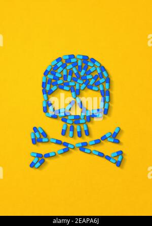 Cranio fatto di pillole di capsula blu. Sfondo giallo Foto Stock