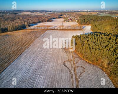 Inverno campo agricolo sotto la neve. Scena aerea. Dicembre paesaggio rurale. Foto Stock