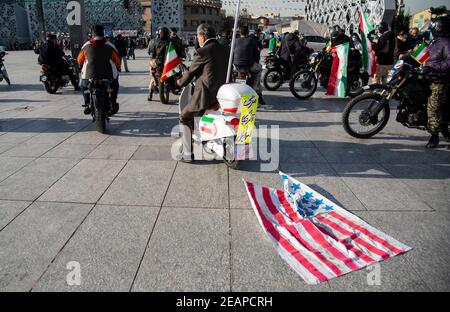 Teheran, Iran. 10 Feb 2021. Un iraniano appende la bandiera americana dietro il suo motociclo durante un rally per commemorare il 42° anniversario della vittoria della rivoluzione islamica, che si è tenuto con le motociclette in mezzo alla pandemia COVID-19 a Teheran, Iran il 10 febbraio 2021. (Foto di Sobhan Farajvan/Pacific Press/Sipa USA) Credit: Sipa USA/Alamy Live News Foto Stock