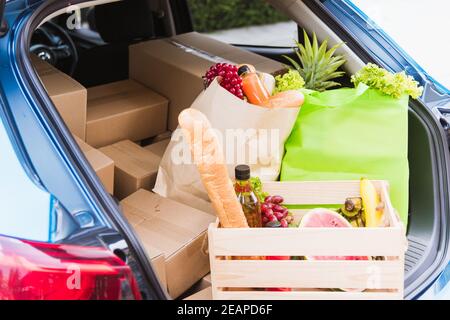 Servizio di alimentari con verdure fresche in cesto di legno sul retro auto Foto Stock