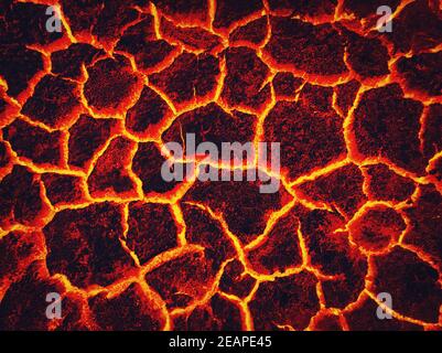 Calore rosso cracked terra texture bruciando dopo l'eruzione del vulcano. Sfondo di tessuto lavico attivo fuso. Armageddon disastro naturale o concetto inferno. La terra si infranisce, si rompe in pezzi. Modello di frattura Foto Stock