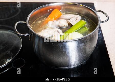 zuppa di ali di pollo è bollita in pentola di acciaio Foto Stock