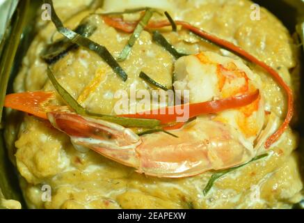 gamberetti al curry al vapore con calamari e cozze avvolti in banana foglia su sfondo bianco Foto Stock