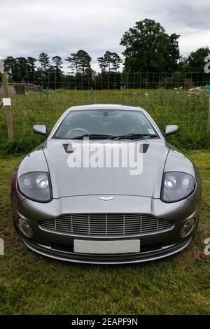 Vista frontale di un lussuoso Grand Tourer Aston Martin Vanquish automobile parcheggiata in un campo di erba ad un rally Foto Stock