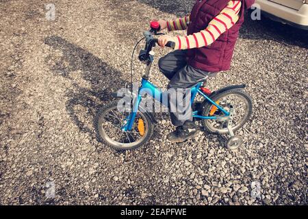 Ragazzo in bici alla strada di ghiaia Foto Stock