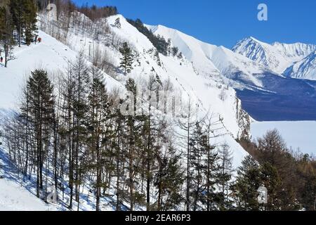 Montagne Baikal in inverno nella neve. Foresta in montagne innevate. Foto Stock