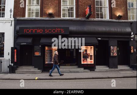 Un uomo cammina oltre il Ronnie Scott's Jazz Club chiuso a Soho, Londra. La maggior parte delle aziende rimangono chiuse nel Regno Unito mentre la nazione continua a combattere con la pandemia del coronavirus. Foto Stock