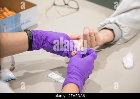 Nurse testa una persona per Covid-19. Foto Stock
