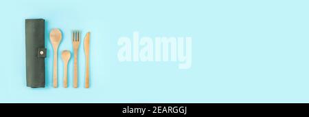 Banner realizzato con posate eco-friendly in bambù su sfondo blu. Concetto di zero sprechi. Foto Stock