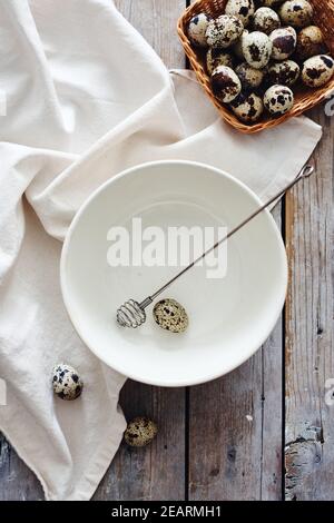 Quail uova in una ciotola su un tavolo di legno, facendo maionese. Foto Stock