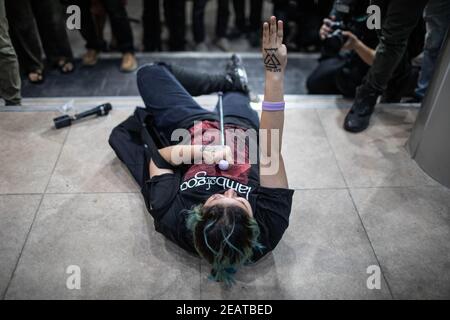 Un manifestante a favore della democrazia rende omaggio a tre dita dopo essere stato rilasciato dalla stazione di polizia di Pathumwan durante una protesta "make noise" per denunciare il recente colpo di Stato militare della giunta in Myanmar e respingere l'articolo 112 del codice penale thailandese.migliaia di manifestanti a favore della democrazia hanno organizzato una dimostrazione, All'esterno del centro commerciale MBK a Siam, chiamato ‘Make Noise', banging utensili da cucina in solidarietà con i manifestanti anti anti di colpo di stato militare in Myanmar, oltre a rifiutare la Sezione 112 del codice penale tailandese. I manifestanti chiedono anche le dimissioni del primo ministro tailandese Prayut Chan-o-cha An Foto Stock