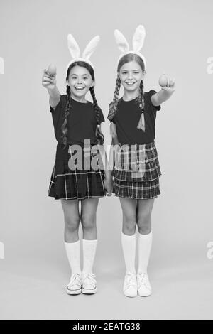 per voi. inizia la caccia alle uova. vacanza primaverile tradizionale. buona pasqua. la primavera è in arrivo. concetto di infanzia felice. ragazze piccole bunny spighe sfondo giallo. bambini simpatici sorella piccola celebrare pasqua. Foto Stock