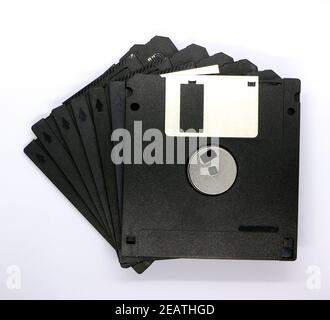 Foto di un file di sette vecchi dischi floppy HD formattati TDK su sfondo bianco Foto Stock