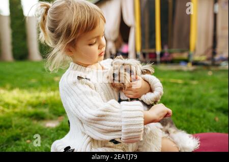 Capretto che abbraccia il cane divertente nel giardino Foto Stock