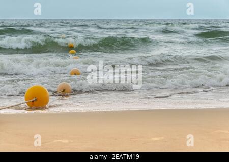 Posto per il nuoto in spiaggia e in zona mare recintato con corda con galleggianti. Vista mare con area piscina recintata con boe Foto Stock