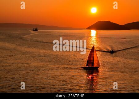 Tramonto sul Mare Adriatico e le sue barche che giocano nei riflessi all'ingresso del porto di Spalato in Croazia. Foto Stock