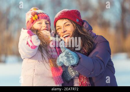 Positivo madre e figlia giocando in winter park Foto Stock